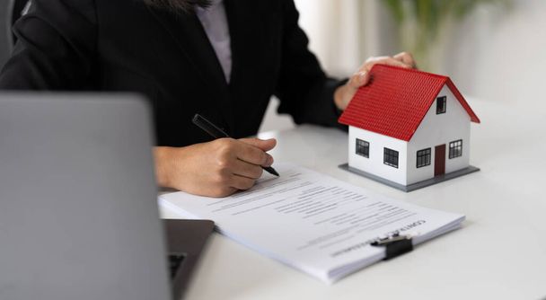 Agenten, die in Immobilieninvestitionen und Hausversicherungen arbeiten, unterzeichnen Verträge im Einklang mit den Verträgen über den Kauf von Eigenheimen, die Käufe für Kunden genehmigen - Foto, Bild