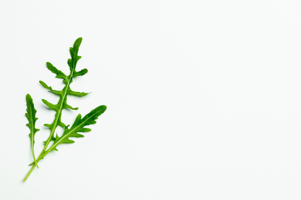 Top view of fresh arugula on white background with copy space - Foto, afbeelding