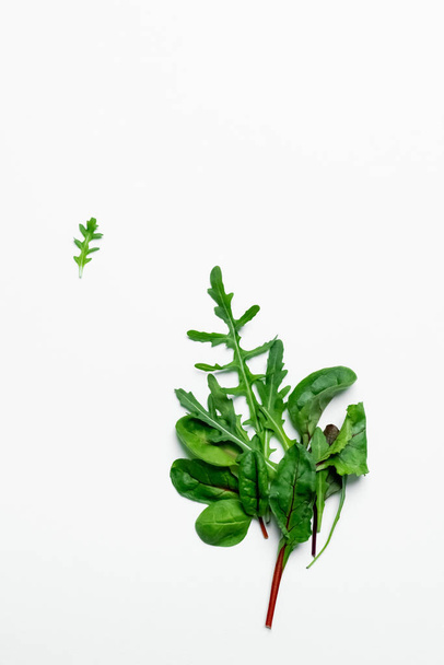 Top view of fresh arugula and spinach on white background  - Valokuva, kuva