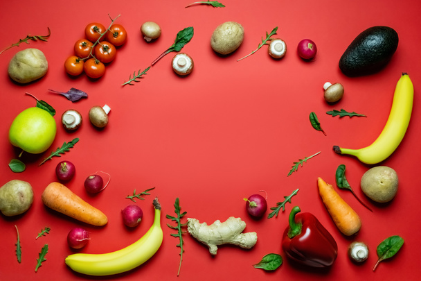 Flat lay with frame from fresh vegetables and fruits on red background  - Valokuva, kuva