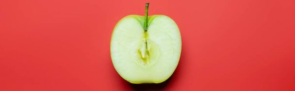 Top view of cut green apple on red background, banner  - Foto, Imagem