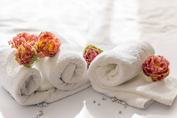 Primer plano, toallas de baño de rizo blanco y flores. - Foto, Imagen