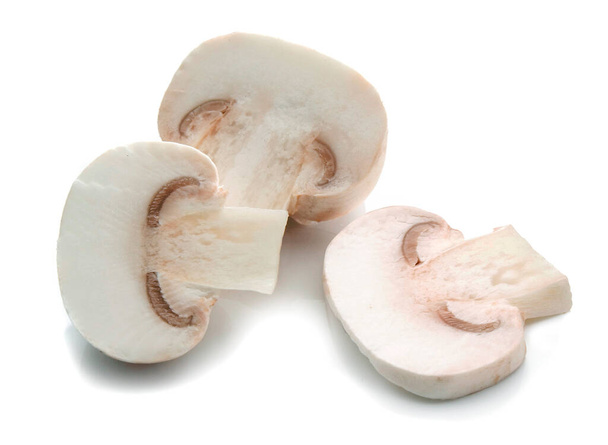 three pieces of champignon mushrooms cut and placed on a white surface - Photo, image