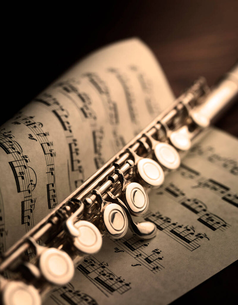 příčná flétna odpočívající na notovém zápisu klasické hudby z osmnáctého století - Fotografie, Obrázek