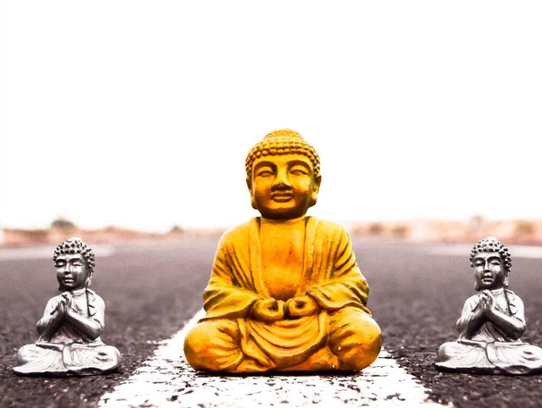 Antigua estatua de Buda en el camino del asfalto - Foto, imagen