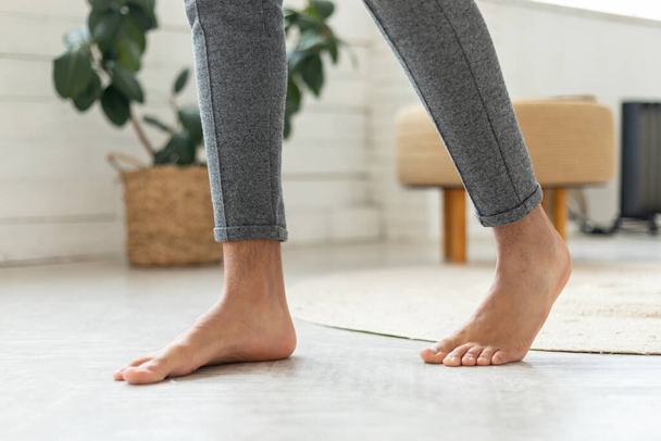 Cropped Shot Of Male Bare Feet Standing On Floor Indoor - Photo, image