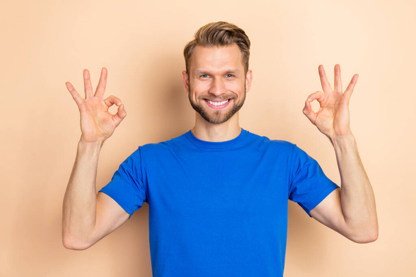 Portrait of cheerful friendly person two arms show okey symbol isolated on beige color background - Fotoğraf, Görsel
