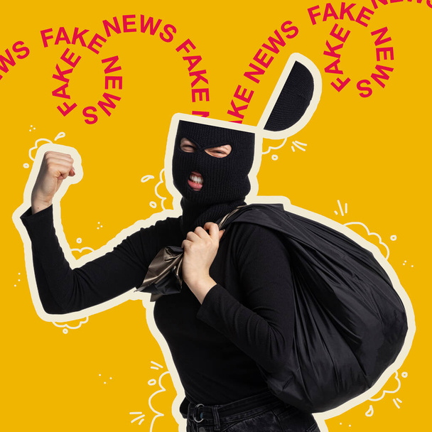 Contemporary art collage. Woman in black suit and balaclava, thief spreading fake information isolated over yellow background - Фото, изображение