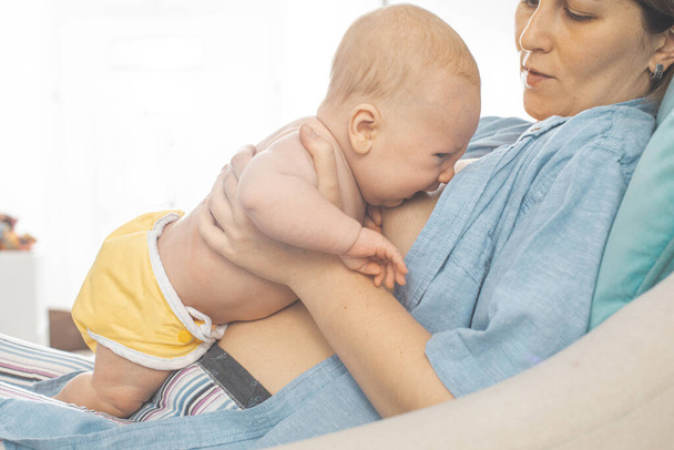 Mothed and baby, breastfeeding in laid back position - 写真・画像