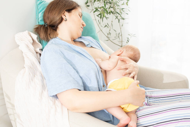 Мама и новорожденный ребенок отдыхают после кормления грудью - Фото, изображение