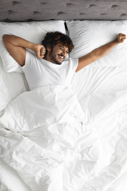 heureux hindou guy étirement dans lit le matin - Photo, image