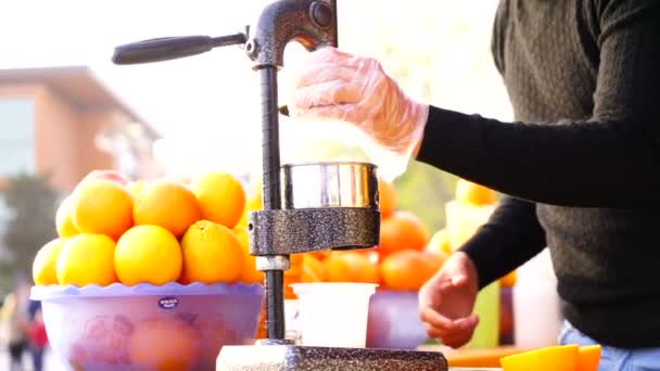 Ein Mann presst Saft aus verschiedenen Früchten, Zitrusfrüchten und Gemüse auf einer Saftpresse. Gesunder Lebensstil, gesunde Ernährung. - Filmmaterial, Video