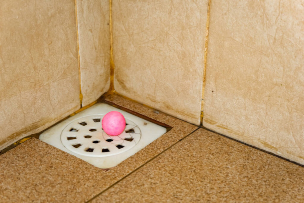 otwór odpływowy w łazience z brązową podłogą płytek - Zdjęcie, obraz