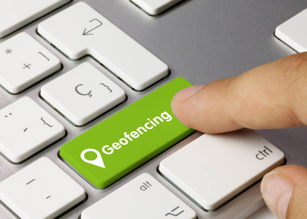 Geofencing Written on Green Key of Metallic Keyboard. Finger pressing key. - Foto, Bild