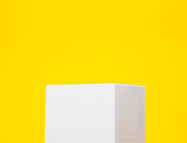 Minimal white podium on a yellow background for product presentation. - Fotografie, Obrázek