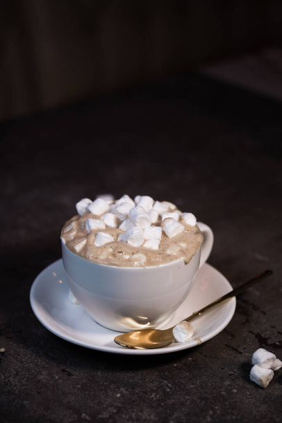 Coffee mug with marshmallows on a light background. Marshmallows are scattered - Photo, image