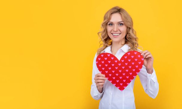 glad woman with red love heart on yellow background - Fotoğraf, Görsel