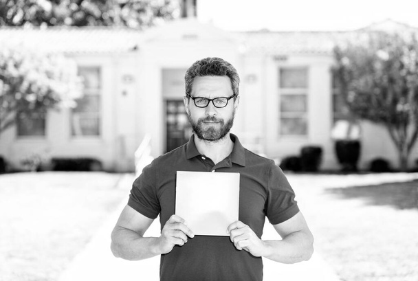 Lehrer mit Brille zeigt Papierbogen zurück in die Schule - Foto, Bild