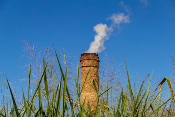 Industrial chimneys emitting dense white smoke. Industry exhaust fan emitting smoke with blue sky in the background. - Fotografie, Obrázek