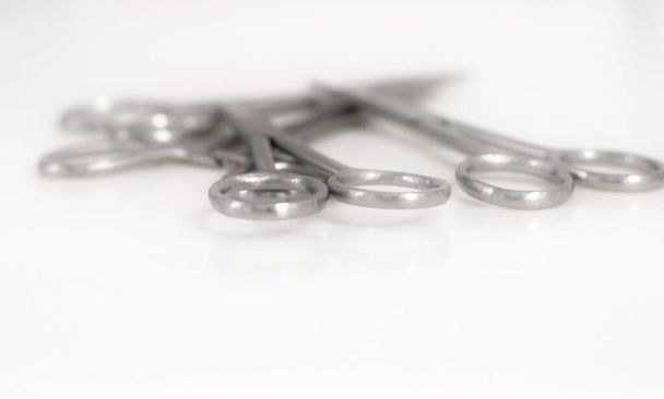 Bunch of surgical scissors on a white background ,shallow depth of field image. - 写真・画像