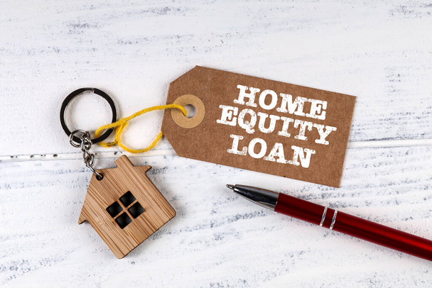 HOME EQUITY LOAN. Price tag and pen on a white wooden table - Photo, Image