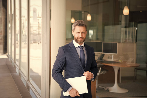 mature smiling businessman in businesslike suit hold wireless laptop outside the office, business - Valokuva, kuva