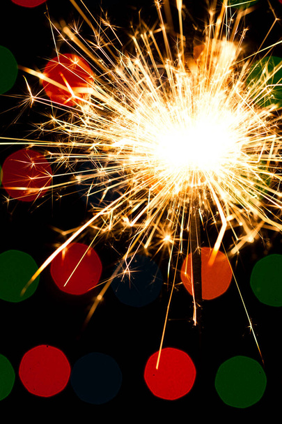 Sparkler background. A sparkler is a type of hand held firework that burns slowly while emitting colored flames, sparks, and other effects - Photo, Image