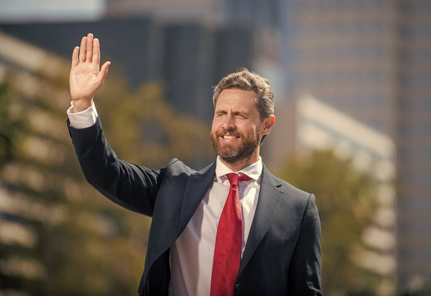 confident bearded boss. cheerful businessman in formalwear waving hello. - Foto, imagen