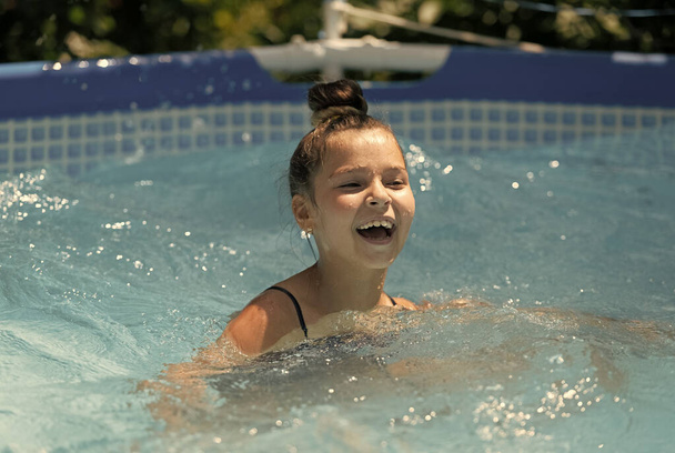 Ragazza felice nuotare nel bagno nella soleggiata giornata estiva, piscina - Foto, immagini