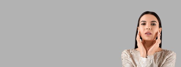 Beautiful fashionable young woman on grey background with space for text - Фото, изображение
