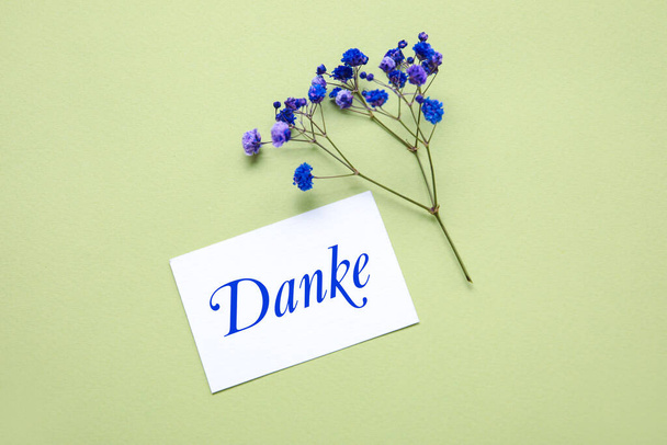 Karta se slovem DANKE (německy poděkování) a květy na zeleném pozadí - Fotografie, Obrázek