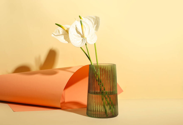 Vase with beautiful anthurium flowers on color background - 写真・画像