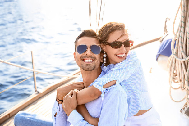 Happy young couple resting on yacht - Φωτογραφία, εικόνα