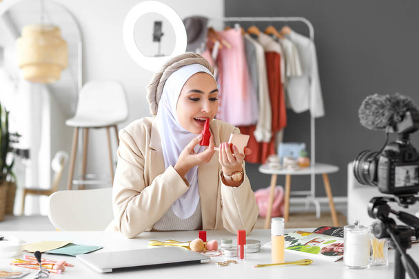 Blogger musulmán de belleza aplicando lápiz labial mientras graba video en vestidor - Foto, Imagen