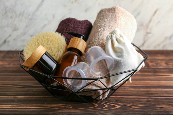 Basket with bath supplies and vacuum jars for anti-cellulite massage on wooden table - Foto, afbeelding