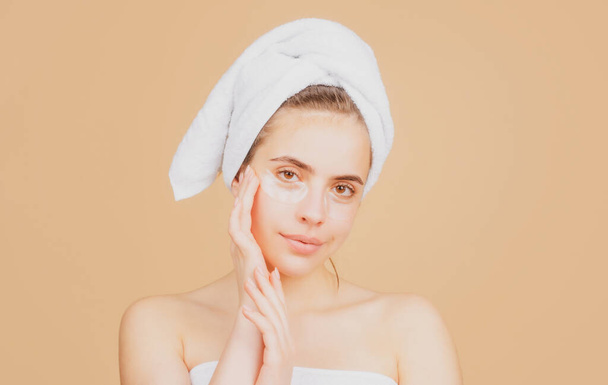 Beauty face of a cheerful attractive girl with towel on head, isolated. Moisturized healthy skin, morning spa, beauty routine, facial treatment. - Fotografie, Obrázek