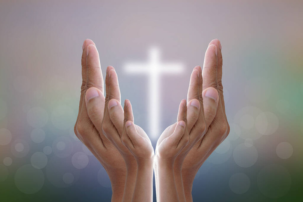 Hands bless the cross in the sky.	 - 写真・画像