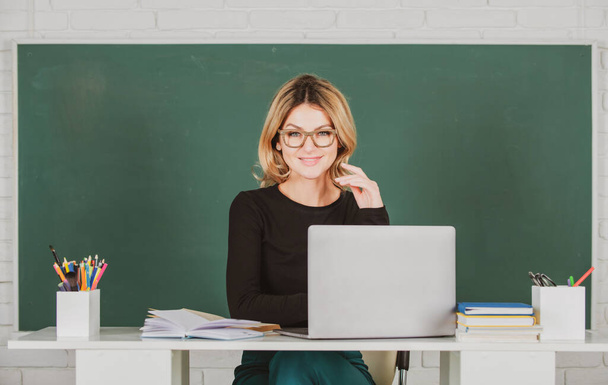 Portrait of female teacher is teaching online through webcam students with computer laptop in classroom. - Φωτογραφία, εικόνα
