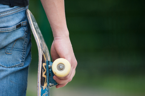 Man holding skateboard - Foto, afbeelding