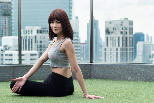 Mulher praticando ioga núcleo corpo torção pose em ambiente urbano, barriga pose para órgãos digestivos internos benefi - Foto, Imagem