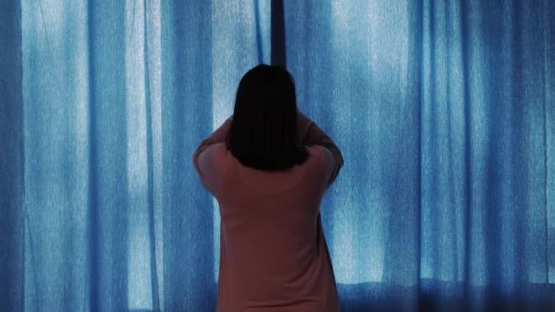 Концепция доброго утра - молодая женщина в пижаме открывает занавески дома или в отеле - Кадры, видео