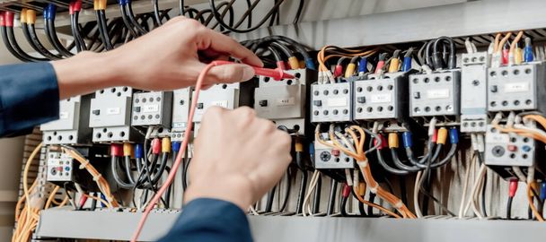 Ingegnere elettricista utilizza un multimetro per testare l'installazione elettrica e la corrente della linea elettrica in un armadio di controllo del sistema elettrico. - Foto, immagini