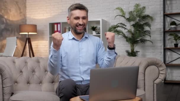 Opgewonden man voorraad handelaar winnaar kijkt laptop vieren van goede aandelenmarkt deal  - Video