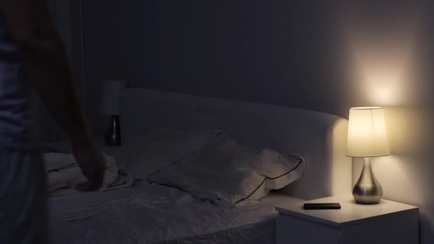 goede nacht - knappe man doet het licht uit en gaat slapen in donkere slaapkamer - Video