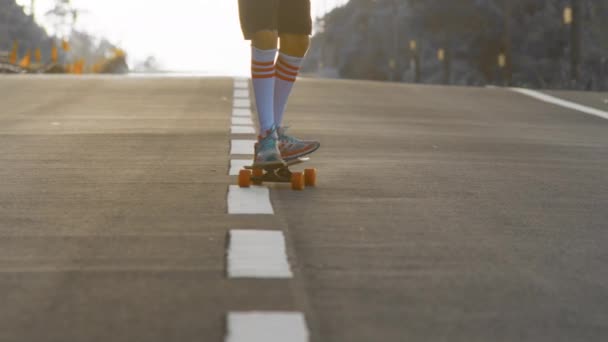 Retrato chico con un longboard en una hermosa carretera. Adolescente skateboarding en las calles de la ciudad - Imágenes, Vídeo