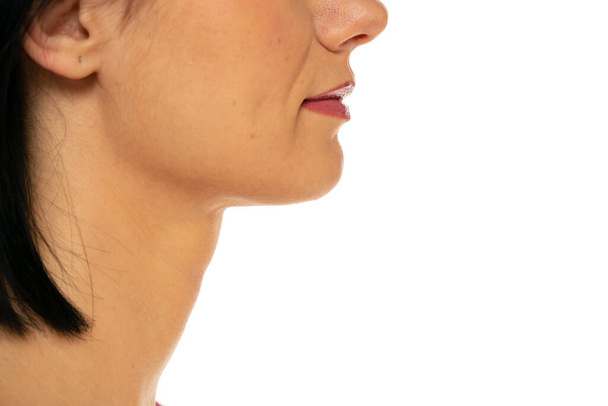 Closeup profile of female s nose, neck and lips on a white background - 写真・画像