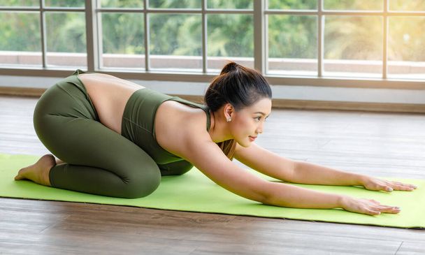 Millennial Asian young healthy slim strong sexy female sporty models in casual crop top sportswear lay down doing posing upward facing dog pose together on yoga mat in pilates classroom studio. - Foto, Imagen