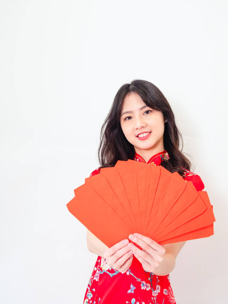 Portrait of Young asian woman wearing traditional cheongsam qipao dress with red envelopes in chinese new year on white background. - Fotografie, Obrázek