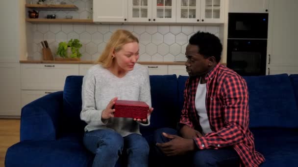 African American man boyfriend gives gift box girlfriend caucasian woman, couple - Filmati, video