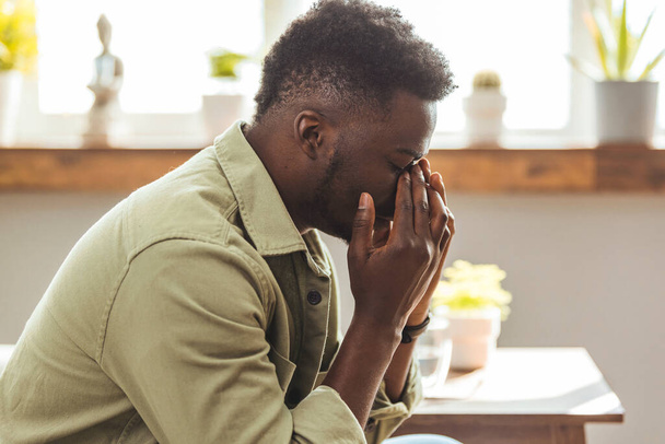 Young handsome man with hand on head for pain in head because stress. Suffering migraine. Headache. Young African man making a pain face.  - 写真・画像